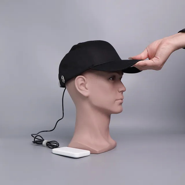 Svart caps med LED-lys på mannequinhode og kabel