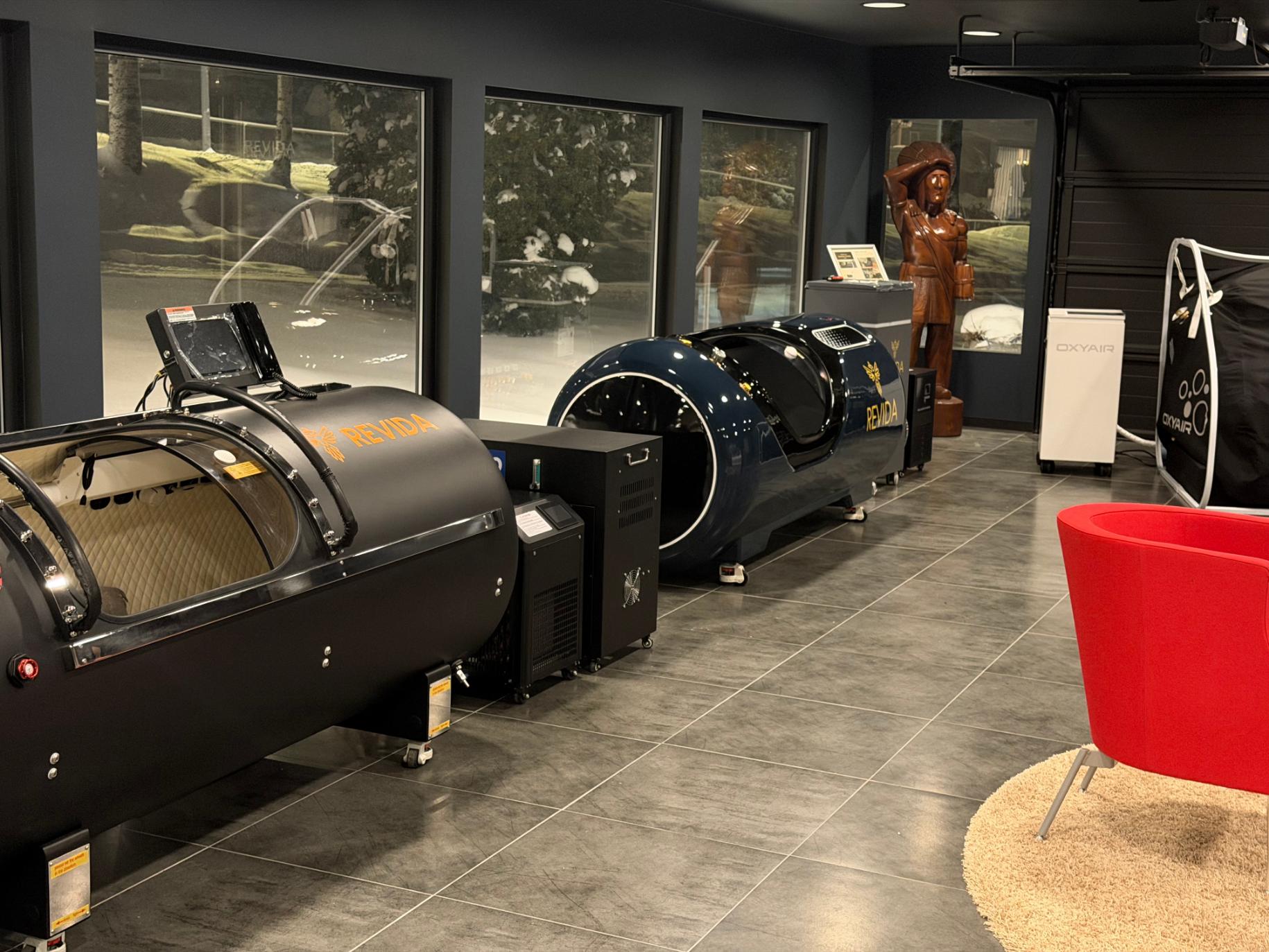 To trykkammer fra Revida står side om side i et moderne rom med store vinduer og flislagt gulv.