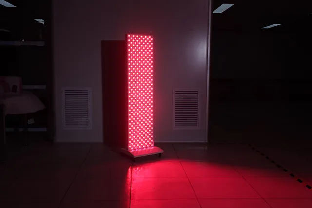 Lysterapipanel i bruk, avgir kraftig rødt lys i et dempet rom.